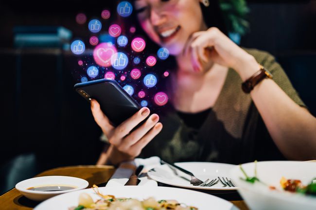 Persoon die een telefoon gebruikt tijdens het diner.