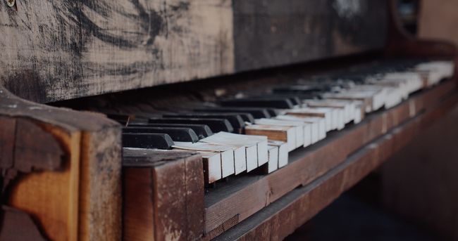 흰색과 검은색 건반이 있는 오래된 갈색 피아노