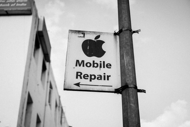 Πινακίδα του δρόμου που λέει " Επισκευή κινητών" κάτω από ένα λογότυπο της Apple