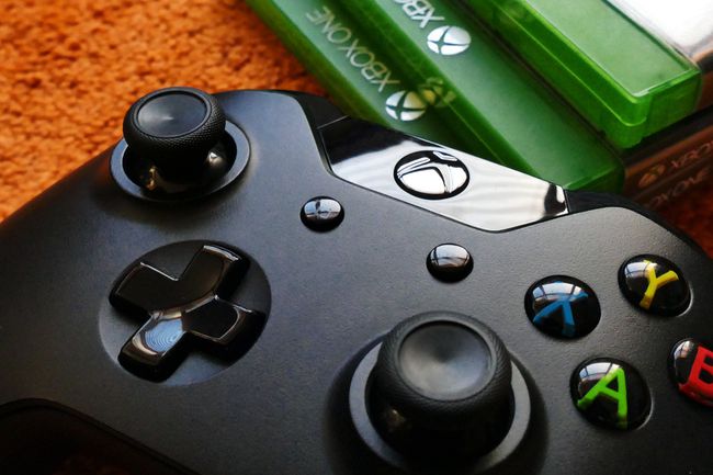 Un controlador de Xbox con juegos de fondo.