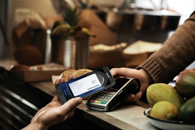 Persoană care utilizează Samsung Pay pentru a efectua o achiziție într-o unitate de vânzare cu amănuntul.