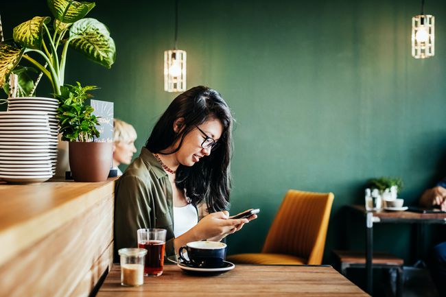 En kvinna som använder en telefon på ett kafé.