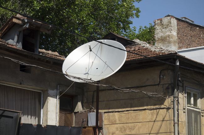 Un'antenna TV satellitare al di fuori di una casa.