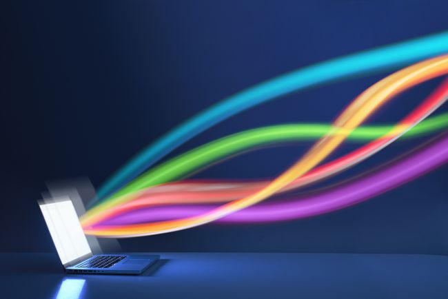 Wiązki światła reprezentujące przepływ danych do laptopa