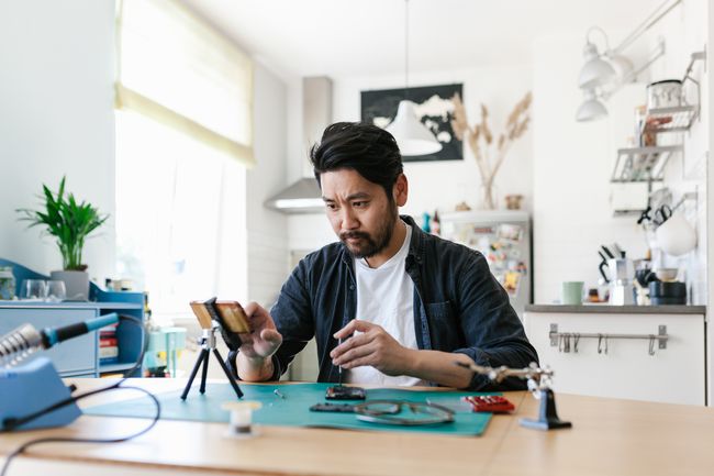 電子機器の修理方法を学ぶためにビデオを見ている人。