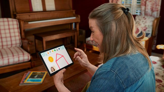 小さなタブレットでAmazonGlowアプリを使用して子供と対話する大人。