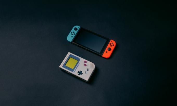 黒い背景に置かれた Nintendo Switch とゲームボーイ。