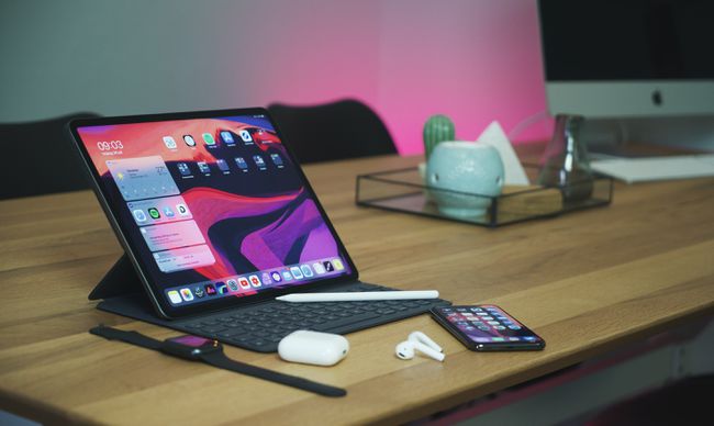 iPad podłączony do klawiatury i spoczywający na stole z innymi produktami Apple