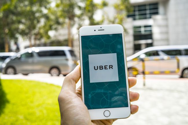 Aplikace Uber na iPhonu drženém v ruce na ulici