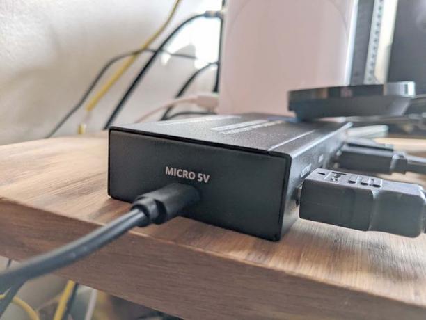 Eine mit Strom versorgte HDMI-Umschaltbox, die an die Stromversorgung angeschlossen ist.