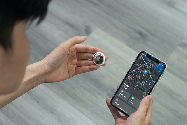 スマートフォンを使用して、保持しているAirTagを追跡している人。