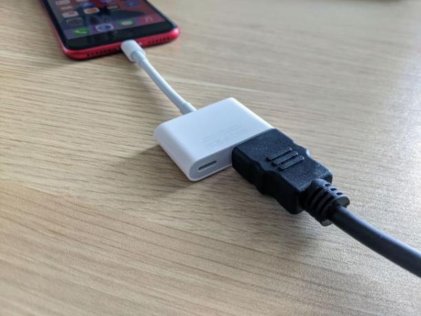Bir iPhone'a adaptörle takılan bir HDMI kablosu.